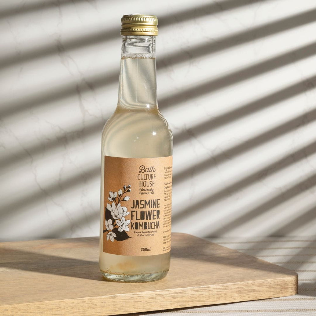 Raw and unpasteurised live kombucha on wooden board. Made in Bristol.