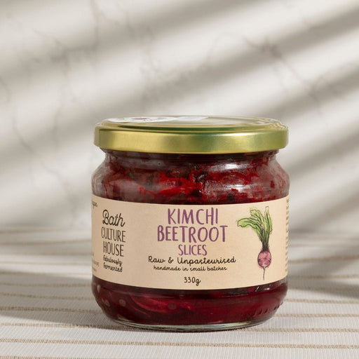 Jar of kimchi beetroot slices with a label on a textured surface. Made in the UK