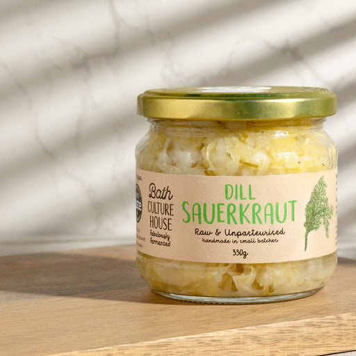 Jar of dill sauerkraut with a label on a wooden surface