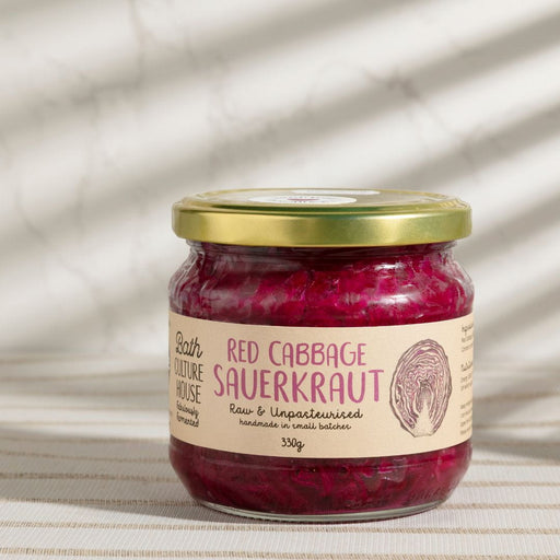 Jar of red cabbage sauerkraut with a label on a textured beige background