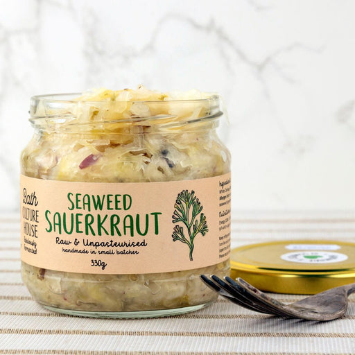 Jar of seaweed sauerkraut with a label on a textured surface and fork